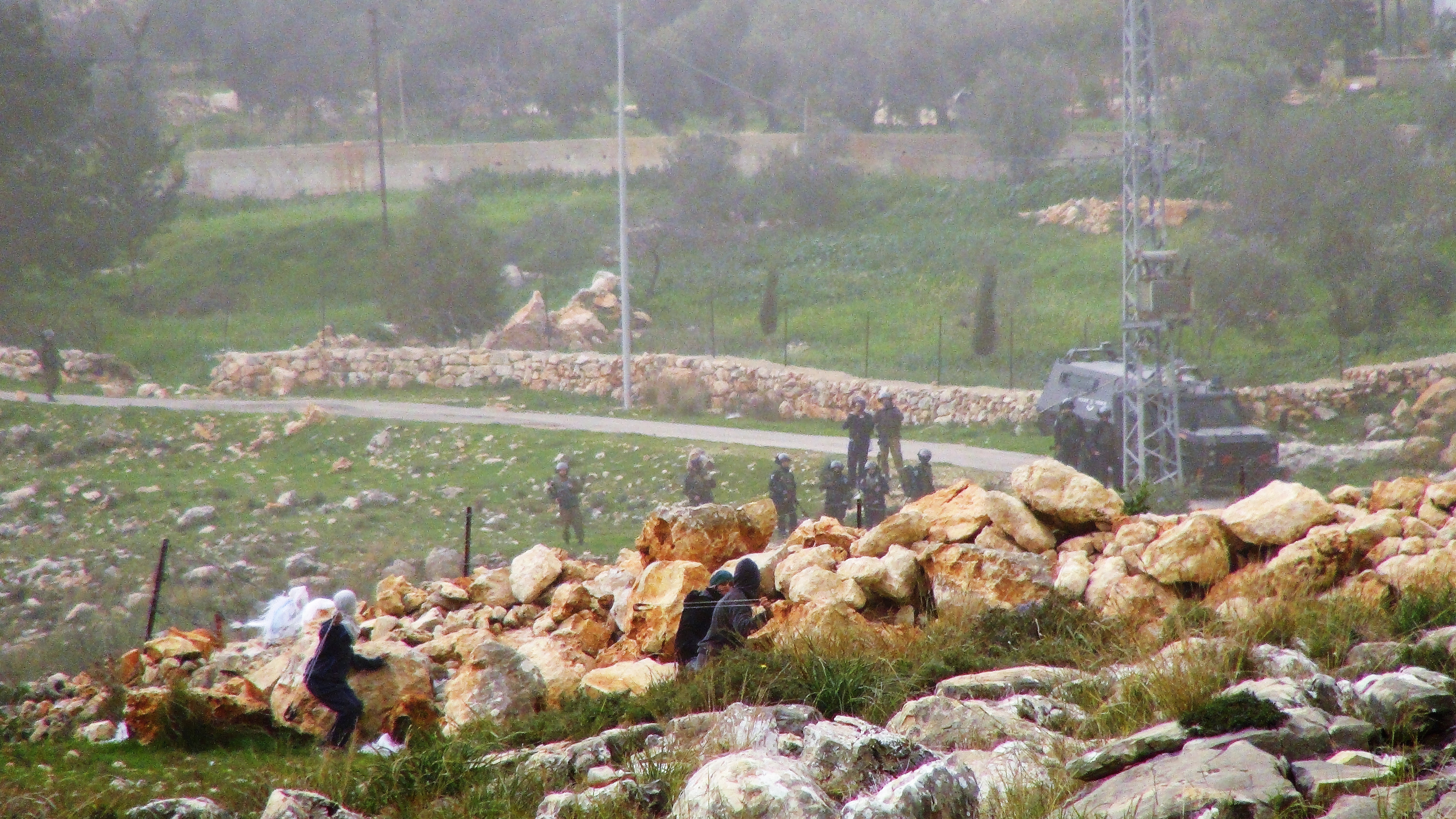 Niños arrojan piedras a soldados armados israelís, quiénes agredieron una marcha pacífica en Bil'in. Muchos de los niños en presión israelí son acusados por tirar piedras.